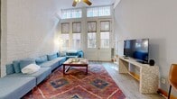 This 850 square foot townhouse in Richmond, VA offers a blend of historic charm and modern comfort. Spread across two floors, the space features exposed brick walls and wooden beams, creating a rustic yet refined ambiance. The first floor hosts an open-concept living area with high ceilings and large windows, flooding the space with natural light. The modern kitchen boasts cherry wood cabinets, stainless steel appliances, and a granite countertop with bar seating. A cozy living room area, adorned with a vibrant area rug, provides a perfect spot for relaxation. The bedrooms, including a 150 square foot primary bedroom, offer ample space and are equipped with in-room laundry facilities. Both bathrooms are well-appointed with modern fixtures and tiled floors. Throughout the home, a neutral color palette is accented by pops of blue and warm wood tones, creating a cohesive and inviting atmosphere. The property's thoughtful layout and design make efficient use of its 850 square feet, offering a comfortable and stylish urban living experience.