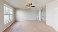 Located at 700 Greenlawn Dr in Columbia, SC, this single-floor 2-bedroom, 2-bathroom home offers a comfortable and functional layout with thoughtful design details throughout. The spacious living room features soft carpeting, crown molding, a ceiling fan with light fixture, and a decorative column that adds an elegant touch. Multiple windows flood the space with natural light, creating a bright and welcoming atmosphere. The kitchen is well-equipped with gray shaker-style cabinetry, granite countertops, stainless steel appliances including a refrigerator, range, and dishwasher, and tile flooring, making it both stylish and practical. The primary bedroom is generously sized, offering two windows with outdoor views, a ceiling fan, carpet flooring, and access to a dedicated closet with built-in shelving. The second bedroom is equally inviting, with a large window overlooking lush greenery and plush carpeting throughout. Both bathrooms are finished with gray vanity cabinetry, white countertops, large mirrors, and warm-toned tile flooring. One bathroom features a full tub-shower combination. Two closets provide ample storage across the home. Neutral tones and consistent finishes create a cohesive, move-in-ready feel throughout the entire space.
