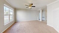 Located at 700 Greenlawn Dr in Columbia, SC, this single-floor 2-bedroom, 2-bathroom home offers a comfortable and functional layout with thoughtful design details throughout. The spacious living room features soft carpeting, crown molding, a ceiling fan with light fixture, and a decorative column that adds an elegant touch. Multiple windows flood the space with natural light, creating a bright and welcoming atmosphere. The kitchen is well-equipped with gray shaker-style cabinetry, granite countertops, stainless steel appliances including a refrigerator, range, and dishwasher, and tile flooring, making it both stylish and practical. The primary bedroom is generously sized, offering two windows with outdoor views, a ceiling fan, carpet flooring, and access to a dedicated closet with built-in shelving. The second bedroom is equally inviting, with a large window overlooking lush greenery and plush carpeting throughout. Both bathrooms are finished with gray vanity cabinetry, white countertops, large mirrors, and warm-toned tile flooring. One bathroom features a full tub-shower combination. Two closets provide ample storage across the home. Neutral tones and consistent finishes create a cohesive, move-in-ready feel throughout the entire space.
