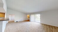 Located at 2 Wyndham Dr in Hampton, Virginia, this one-bedroom, one-bathroom residence offers a well-organized single-floor layout designed for comfortable everyday living. The open-concept living area flows seamlessly into the kitchen, where warm honey-toned cabinetry, dark countertops, tile flooring, and a suite of stainless steel appliances — including a refrigerator, range, and microwave — create a functional and attractive space. A peninsula counter separates the kitchen from the carpeted living room, which receives natural light through a sliding glass door that opens to a private balcony with outdoor views. An in-unit laundry area is conveniently accessible from the living space. The bedroom is a comfortable, carpeted retreat featuring a ceiling fan, a window with outdoor views, and access to a generously sized walk-in closet outfitted with white wire shelving, hanging rods, and built-in shelving units — providing ample storage. The full bathroom includes a tile-surround tub and shower combination, a toilet, and a vanity with a large mirror and warm wood cabinetry. Neutral tones, carpet throughout the main living and sleeping areas, and practical finishes give this residence a clean and move-in ready feel.