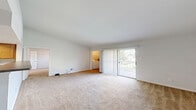 Located at 2 Wyndham Dr in Hampton, Virginia, this one-bedroom, one-bathroom residence offers a well-organized single-floor layout designed for comfortable everyday living. The open-concept living area flows seamlessly into the kitchen, where warm honey-toned cabinetry, dark countertops, tile flooring, and a suite of stainless steel appliances — including a refrigerator, range, and microwave — create a functional and attractive space. A peninsula counter separates the kitchen from the carpeted living room, which receives natural light through a sliding glass door that opens to a private balcony with outdoor views. An in-unit laundry area is conveniently accessible from the living space. The bedroom is a comfortable, carpeted retreat featuring a ceiling fan, a window with outdoor views, and access to a generously sized walk-in closet outfitted with white wire shelving, hanging rods, and built-in shelving units — providing ample storage. The full bathroom includes a tile-surround tub and shower combination, a toilet, and a vanity with a large mirror and warm wood cabinetry. Neutral tones, carpet throughout the main living and sleeping areas, and practical finishes give this residence a clean and move-in ready feel.