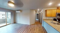 Located at 242 SW Cherry Park Rd in Troutdale, Oregon, this single-floor residence offers a thoughtfully designed layout with a clean, modern aesthetic throughout. The open-concept living and dining area features light wood-style vinyl plank flooring, recessed lighting, and a wall-mounted mini-split HVAC unit for year-round comfort. Sliding glass doors lead to a private balcony, filling the space with natural light and providing views of the surrounding neighborhood.

The kitchen is well-equipped with warm-toned wood cabinetry, granite countertops, a breakfast bar peninsula, stainless steel appliances including a refrigerator, range, and microwave, and recessed ceiling lighting. The adjacent living area flows seamlessly, creating an inviting and functional common space.

The bedrooms are carpeted and comfortably sized, each featuring windows that bring in natural light and offer views of the neighboring buildings and greenery. The two bathrooms are finished with hardwood-style flooring, granite-topped vanities with wood cabinetry, and large mirrors. One bathroom includes a walk-in shower with glass doors, while the other features a full soaking tub with shower. Together, these spaces create a comfortable, move-in-ready home in the Troutdale community.