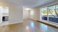 Located at 122 Bronte St S in Milton, Ontario, this well-appointed one-bedroom, one-bathroom unit offers a comfortable and functional layout. Parquet hardwood flooring flows throughout the living spaces, lending a classic warmth to the interior. The open living room is bathed in natural light through a large sliding door that leads directly to a private balcony, where lush, mature trees frame a peaceful neighbourhood view. A secondary window further brightens the space, creating an airy and welcoming atmosphere. The kitchen has been updated with modern grey two-tone cabinetry, white quartz countertops, a stainless steel sink, and stainless steel appliances including an electric range and over-the-range microwave. Light tile flooring adds a clean, contemporary feel to this functional cooking space. The bedroom is a comfortable size, featuring parquet flooring, a window overlooking the greenery outside, a sliding closet, and a baseboard heating unit. In total, three closets throughout the unit provide generous storage. The bathroom is finished with clean white tile surrounding a full soaker tub and shower with chrome fixtures. Textured ceilings are present throughout, adding a distinctive character to this charming Milton residence.