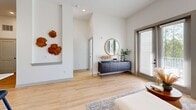 Located at 223 Long Shoals Rd in Asheville, NC, this well-appointed 2-bedroom, 2-bathroom unit offers a thoughtfully designed open-concept layout with light hardwood flooring and soaring ceilings throughout. The kitchen serves as the heart of the home, showcasing white shaker cabinetry, stainless steel appliances, a subway tile backsplash, and a large center island with quartz countertops and seating for multiple guests, illuminated by stylish pendant lighting. The kitchen flows seamlessly into the living area, which benefits from generous natural light through large windows and sliding glass doors that open to an outdoor space. The primary bedroom features bright windows with views of lush greenery, creating a serene retreat. The en-suite bathroom is finished with a dual-sink vanity with quartz countertops, matte black fixtures, a framed mirror, and a glass-enclosed walk-in shower. The second bedroom also enjoys direct outdoor access through a glass door, flooding the room with natural light. The second bathroom features large-format tile, a soaking tub, and tasteful finishes. A dedicated closet adds to the functional storage throughout. The clean, neutral palette and modern design details create a bright and cohesive living environment.