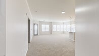Located at 13957 College Blvd in Olathe, Kansas, this single-floor residence offers a thoughtfully designed open-concept layout filled with natural light. The expansive living area features plush neutral carpeting, crown molding, and large windows with blinds that bathe the space in natural light. The kitchen is a standout, showcasing dark espresso cabinetry, stainless steel appliances including a refrigerator and microwave, a mosaic tile backsplash, and a generously sized granite-topped island with pendant lighting overhead — seamlessly connecting the kitchen to the main living space. The primary bedroom is generously proportioned, featuring a ceiling fan, large windows, and access to a walk-in closet outfitted with wire shelving systems. An additional bedroom offers carpeted floors and arched-panel interior doors. A sun-filled bonus room lined with multiple windows provides versatile living space. Both bathrooms are finished with rich hardwood-style flooring, dark wood vanities, granite countertops, framed mirrors, and full soaking tub and shower combinations. Crown molding and consistent neutral tones throughout the home create a cohesive and polished aesthetic, making this a comfortable and well-detailed single-level residence.
