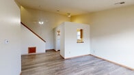 Located at 1510 Russell Dr in Streetsboro, Ohio, this two-story, three-bedroom, two-bathroom home offers a practical and comfortable layout spread across two floors. The main level forms the heart of the home, featuring an open living area with wood-look laminate flooring, a ceiling fan, and vaulted ceilings that lend a sense of openness and volume. A tiled entryway welcomes you inside, transitioning seamlessly into the living space. The kitchen is efficiently designed in a U-shaped configuration, featuring wood-toned cabinetry with white lower cabinets, white countertops, a double-basin sink, a dishwasher, and a window that brings in natural light. A pass-through window connects the kitchen to the living area, enhancing the open feel. A staircase leads to the upper level, where additional living space is found. The bedrooms feature wood-look flooring and are served by two full bathrooms, each equipped with a tub-shower combination featuring decorative surround panels. Bedrooms include closets with sliding or hinged wood-toned doors. The primary bedroom is generously proportioned, offering ample space for a full suite of furniture. Throughout, neutral wall tones and consistent flooring create a cohesive, move-in-ready environment.