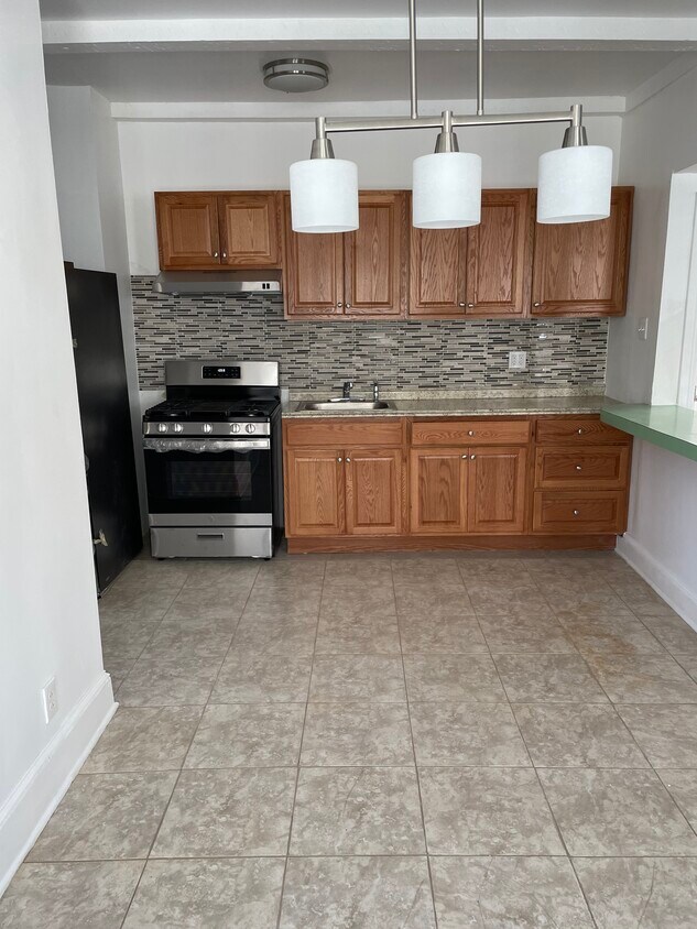 Open airy kitchen dining room. Tile floors in kitchen, bathroom. New laminated floors in 4 bedrooms. - 669 Essex St