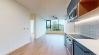 This 570 square foot apartment in Washougal, Washington, offers a harmonious blend of modern design and functional living. The single-floor layout comprises one bedroom, one bathroom, a living room, kitchen, and closet space. The apartment's standout feature is its expansive windows, providing panoramic views of the surrounding landscape and flooding the space with natural light.

The living area boasts light-toned wood flooring that complements the crisp white walls, creating an airy atmosphere. A wall-mounted air conditioning unit ensures year-round comfort. The bedroom, measuring 100 square feet, continues the bright, open feel with large windows and ample floor space.

The kitchen is a model of contemporary design, featuring striking blue cabinetry that contrasts beautifully with the white backsplash and stainless steel appliances. It includes a built-in microwave, oven, and refrigerator, with under-cabinet lighting adding a touch of sophistication.

The bathroom, while compact, is thoughtfully designed with a clean, white color scheme. It includes a vanity with a blue base, matching the kitchen's aesthetic, and is equipped with essential fixtures and grab bars for accessibility.

Throughout the apartment, recessed lighting and large windows work in tandem to create a bright, inviting environment. The open-concept design maximizes the use of space, making this compact apartment feel surprisingly spacious and ideal for modern, efficient living.