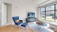 Located at 1003 Ridgewalk Pkwy in Woodstock, GA, this thoughtfully designed one-bedroom, one-bathroom residence offers a cohesive modern aesthetic across its single floor. The open-concept layout connects the kitchen, dining, and living areas seamlessly, creating an efficient and inviting flow throughout the space.

The kitchen is a standout feature, boasting white cabinetry with gold hardware, a textured tile backsplash, stainless steel appliances, quartz countertops, and a central island with bar seating — ideal for both cooking and casual dining. Pendant lighting adds a warm, refined touch overhead.

The living room is bright and airy, anchored by large floor-to-ceiling windows that flood the space with natural light and offer outdoor views. A tray ceiling with a statement gold sputnik chandelier elevates the room's design, while light hardwood flooring runs throughout the main living areas.

The bedroom is a serene retreat featuring soft carpet, a decorative wall panel with a sage green accent, a ceiling fan, and generous natural light from large windows. The adjoining bathroom offers a clean, modern vanity with ample storage, warm-toned wood accents, and stylish lighting. A dedicated closet provides practical storage. The overall ambiance is contemporary, bright, and welcoming.