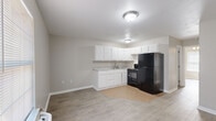 Located at 719 AR-365 in Mayflower, Arkansas, this single-story, 2-bedroom, 1-bathroom unit offers a practical and well-appointed layout. Throughout the unit, light-toned wood-look flooring creates a cohesive and easy-to-maintain foundation, complemented by neutral beige walls and clean white trim.

The open kitchen features white cabinetry offering ample storage, a countertop sink, black appliances including an electric range and a full-size refrigerator, and tile flooring that transitions smoothly into the main living area. Flush-mount ceiling lighting keeps the space bright and functional.

Both bedrooms are equipped with ceiling fans with light fixtures, providing comfort and air circulation. Natural light enters through windows fitted with white blinds, and the primary bedroom includes a closet. The rooms maintain a clean, simple aesthetic consistent with the rest of the unit.

The bathroom includes a full-size soaking tub and shower combination with a solid surround and a safety grab bar, making it a practical and accessible space.

Overall, this unit presents a straightforward, move-in-ready layout well-suited for those seeking functional living accommodations in the Mayflower area.
