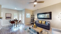 This single-floor residence is thoughtfully designed to maximize comfort and functionality. The open-concept living and dining area serves as the heart of the home, featuring wood-look flooring, vaulted ceilings with a ceiling fan, and large windows with vertical blinds that invite abundant natural light. The living space offers a welcoming ambiance accentuated by neutral-toned walls and a seamless flow between areas.

The kitchen is outfitted with crisp white cabinetry, granite countertops, and a window overlooking the outdoors, providing both practicality and a bright workspace. Matching granite surfaces extend into the bathrooms, which include a full tub-shower combo and wood-look flooring, maintaining a cohesive design language throughout.

The primary bedroom is a serene retreat with plush carpeting, a ceiling fan, large windows with draping curtains, and access to a walk-in closet. A secondary bedroom features bunk bed accommodations, carpeted flooring, a closet, and a bright window — well-suited for flexible use. An additional bedroom mirrors the primary in style and comfort.

Overall, the residence presents a clean, modern aesthetic with consistent finishes, practical layouts, and thoughtful details that contribute to a warm, livable environment.