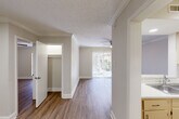 Located in Metairie, Louisiana, this well-appointed one-bedroom, one-bathroom unit offers a practical and comfortable single-floor layout. Throughout the space, warm hardwood-style flooring and crisp white crown molding create a clean, cohesive aesthetic complemented by neutral wall tones and generous natural light.

The living room is an inviting, open area anchored by a ceiling fan and a sliding glass door with vertical blinds that frames views of the surrounding greenery while filling the room with natural light. A pass-through window connects the living area to the kitchen, enhancing the open feel of the layout.

The galley-style kitchen is efficiently designed, featuring light-toned cabinetry, a double-basin stainless steel sink, ample counter space, and full appliances including a refrigerator and electric range — all supported by hardwood-style flooring that continues from the main living areas.

The spacious bedroom accommodates comfortable furnishings with ease, benefiting from a ceiling fan, a window with natural light, and a dedicated walk-in closet for generous storage. The bathroom includes a full tub and shower combination with clean white tile surround. Textured ceilings and consistent crown molding throughout tie the entire space together with a unified, tidy finish.