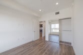 Located at 5801 W Pico Blvd, Unit 601 in Los Angeles, this modern single-floor residence offers a clean, contemporary design with an open-concept layout filled with natural light. Light-toned hardwood flooring flows seamlessly throughout the living areas and bedroom, lending warmth and continuity to the space.

The living area is bright and airy, anchored by recessed lighting and crisp white walls. A sliding glass door opens to a private balcony, inviting in natural light and outdoor views of the surrounding Los Angeles neighborhood. The kitchen is efficiently designed with sleek gray flat-front cabinetry, white countertops, a tile backsplash, and a full suite of stainless steel appliances, including a gas range, microwave, dishwasher, and refrigerator.

The bedroom features a generous sliding-door closet with built-in drawers and shelving, offering ample storage. The bathroom is finished with neutral large-format floor and wall tiles, a glass-enclosed tub and shower combination, a wall-mounted sink, and a frameless mirror, creating a clean and functional space.

The unit also includes an in-unit washer and dryer, a bold dark entry door with a smart lock, and a well-organized floor plan that maximizes every square foot of the space.