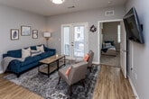 Located at 651 Rain Forest Rd in Knoxville, Tennessee, this single-floor residence offers a well-designed layout with modern finishes and a cohesive neutral color palette throughout. The kitchen is a standout feature, equipped with dark espresso cabinetry, light countertops, stainless steel appliances, a built-in microwave, and a double-basin sink. Pendant lighting adds a refined touch, while wood-look flooring ties the space together seamlessly into the adjacent hallway and living areas. The living room is bright and welcoming, with access to an outdoor area through glass-paned doors that invite natural light. The space comfortably accommodates a seating area centered around a wall-mounted television. Each bedroom features plush carpeting, ceiling fans, and windows with blinds that provide ample natural light and privacy. One bedroom includes a walk-in closet, offering generous storage. The bathrooms are finished with dark vanity cabinetry, white countertops, and wood-look flooring, maintaining the consistent design language found throughout the residence. The overall ambiance is clean, contemporary, and functional, making this Knoxville property a practical and stylish living space.