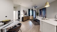 Located at 201 W Coolidge St in Phoenix, AZ, this thoughtfully designed one-bedroom, one-bathroom residence offers a modern aesthetic with high-quality finishes throughout. The open-concept layout seamlessly connects the kitchen and living area, maximizing the efficient use of space. Light wood-tone flooring runs through the main living areas, creating a warm and cohesive feel.

The kitchen is a standout feature, equipped with crisp white cabinetry accented by gold hardware, a striking black herringbone tile backsplash, and a full suite of stainless steel appliances including a gas range, microwave, and French door refrigerator. A peninsula with white quartz countertops and bar seating, illuminated by a pair of gold pendant lights, serves as both a functional workspace and a casual dining spot.

The living area is bright and open, featuring a ceiling fan and access to natural light through a glass-paneled entry door. The bedroom offers a comfortable retreat with plush carpeting, a textured wood slat accent wall, a large window with outdoor views, and direct access to a dedicated walk-in closet. The bathroom is clean and contemporary, featuring white cabinetry with gold hardware, a wide vanity with a white countertop, and wood-look tile flooring.