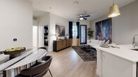 Located at 201 W Coolidge St in Phoenix, AZ, this thoughtfully designed one-bedroom, one-bathroom residence offers a modern aesthetic with high-quality finishes throughout. The open-concept layout seamlessly connects the kitchen and living area, maximizing the efficient use of space. Light wood-tone flooring runs through the main living areas, creating a warm and cohesive feel.

The kitchen is a standout feature, equipped with crisp white cabinetry accented by gold hardware, a striking black herringbone tile backsplash, and a full suite of stainless steel appliances including a gas range, microwave, and French door refrigerator. A peninsula with white quartz countertops and bar seating, illuminated by a pair of gold pendant lights, serves as both a functional workspace and a casual dining spot.

The living area is bright and open, featuring a ceiling fan and access to natural light through a glass-paneled entry door. The bedroom offers a comfortable retreat with plush carpeting, a textured wood slat accent wall, a large window with outdoor views, and direct access to a dedicated walk-in closet. The bathroom is clean and contemporary, featuring white cabinetry with gold hardware, a wide vanity with a white countertop, and wood-look tile flooring.