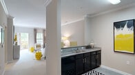 This well-appointed two-bedroom, two-bathroom single-floor residence in Garner, NC offers a thoughtfully designed layout that maximizes comfort and functionality. The open-concept living area is anchored by a spacious living room featuring plush carpeting, crown molding, and natural light streaming through large windows. The adjacent dining area provides an intimate setting, flowing seamlessly into the kitchen, which is equipped with dark cabinetry, granite-style countertops, black appliances, and a double-basin sink — ideal for both everyday meals and entertaining.

The primary bedroom is generously sized, offering soft carpet, natural light from dual windows, and direct access to a closet for ample storage. The second bedroom is equally comfortable and well-lit. Both bathrooms are finished with tile flooring, dark vanity cabinetry, and granite-style countertops, maintaining a consistent design aesthetic throughout.

A dedicated in-unit laundry closet with full-size washer and dryer hookups adds everyday convenience. With three closets total, storage is plentiful. The neutral warm-gray palette, crown molding details, and consistent finishes across rooms create a cohesive and inviting atmosphere throughout this Garner home.