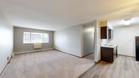 Located at 2054 S 102nd St in West Allis, Wisconsin, this single-floor residence offers 2 bedrooms and 2 bathrooms in a practical and well-organized layout. The combined living room, dining room, and kitchen area forms the heart of the home, providing an open and versatile space. The living area features neutral-toned carpet, a baseboard heating system, and a window that brings in natural light with views of the surrounding neighborhood. The kitchen is equipped with dark espresso cabinetry, granite-look countertops, a stainless steel sink, and black appliances including a gas range and refrigerator, all set atop wood-look vinyl flooring. Both bedrooms are carpeted and include windows with blinds and baseboard heating, offering comfortable, functional spaces. Four closets throughout the unit provide generous storage. The primary bathroom features marble-style tile surrounding a full soaking tub and shower, with wood-look flooring and a dark vanity. The second bathroom is clean and efficient, with a pedestal sink, framed mirror, and matching flooring. A connecting hallway ties all the spaces together in a cohesive, easy-to-navigate floor plan.