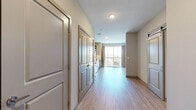 Located at 7600 Cabot Dr in Nashville, Tennessee, this single-floor unit offers a thoughtfully designed layout that maximizes functionality and comfort. Light wood-look flooring flows throughout the main living areas, complemented by neutral wall tones that create a clean, contemporary aesthetic.

The kitchen is a standout feature, equipped with stainless steel appliances including a range, over-the-range microwave, refrigerator, and dishwasher. Granite countertops, a classic white subway tile backsplash, and soft gray shaker-style cabinetry with modern hardware complete the polished look. The open hallway connects the kitchen to the main living space, which is bright and airy, benefiting from a sliding barn-style door and access to a private balcony that brings in natural light.

The bathroom is well-appointed with a generous vanity featuring granite countertops, dark wood cabinetry, and a wide mirror with overhead lighting. The walk-in closet offers ample storage with wire shelving and carpeted flooring for added comfort underfoot. A separate carpeted room provides additional flexible living or sleeping space, accented by a ceiling fan. The hallway ties all areas together, ensuring a smooth and practical flow throughout the unit.