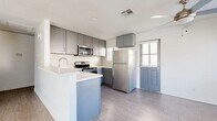 Located in San Bernardino, CA, this single-story, 2-bedroom, 2-bathroom home offers a clean, modern aesthetic throughout. The open-concept kitchen and living room serve as the heart of the home, anchored by a well-appointed kitchen featuring gray shaker-style cabinetry, a patterned tile backsplash, light quartz countertops, a peninsula with a built-in sink, and a full suite of stainless steel appliances including a refrigerator, range, microwave, and dishwasher. Light wood-look flooring runs throughout, lending a cohesive and contemporary feel. The living room is bright and airy, with a sliding glass door that fills the space with natural light and opens to an outdoor area with scenic mountain views. Both bedrooms are well-sized, featuring the same light flooring, neutral walls, and windows with blinds. The primary bedroom offers a comfortable footprint with its own dedicated closet. Each bathroom is finished with gray vanity cabinetry, stone-look countertops, and chrome fixtures; one bathroom includes a tub-shower combination. A dedicated laundry room houses a full-size GE washer and dryer with overhead shelving, adding everyday convenience to this thoughtfully designed home.