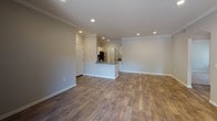 Located at 11711 Collett Ave in Riverside, CA, this single-floor unit offers a well-designed layout with a clean, modern aesthetic throughout. The open-concept living and dining area is highlighted by rich wood-style flooring, crown molding, and recessed lighting, creating a bright and welcoming atmosphere. Sliding glass doors lead to a private balcony, bringing in natural light and outdoor views of the surrounding greenery.

The kitchen features white cabinetry with sleek hardware, a peninsula counter ideal for casual dining, stainless steel appliances including an electric range with over-the-range microwave, and a stainless steel refrigerator — combining both style and functionality.

The bedrooms are finished with plush carpeting and receive ample natural light through window treatments. Ceiling fans add comfort, and closet space is provided for practical storage.

The bathrooms are tastefully appointed with wood-style flooring, white vanity cabinetry, dark countertops, large mirrors, and well-lit vanity fixtures. One bathroom includes a tub-shower combination, offering everyday convenience.

A dedicated in-unit laundry area with a full-size washer and additional shelving rounds out this practical and comfortable home in Riverside.