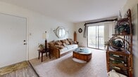 Located at Oak Forest Parkway in Saint Louis, Missouri, this 2-bedroom, 1-bathroom residence offers a well-organized single-floor layout designed for comfortable everyday living. The living room is a welcoming, carpeted space anchored by a large sliding glass door that fills the room with natural light and provides outdoor views. Adjacent to the living area, the dining room features wood-style plank flooring, a chandelier overhead, and an open sightline to the kitchen, creating a cohesive and functional common area. The kitchen is equipped with wood-toned cabinetry, laminate countertops, stainless steel appliances including a full-size refrigerator, and hardwood-style flooring, with a louvered door adding a classic touch. The primary bedroom is a generously sized, carpeted retreat highlighted by a warm terracotta accent wall, a large window with outdoor views, and ample room for full-sized furniture. The second bedroom is similarly carpeted and bright. The bathroom features tile flooring, a tub-shower combination, and a wood-toned vanity. A hallway and closet complete the layout, contributing to the unit's efficient use of space throughout.