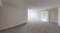 Located at 2128 Haven Rd, Unit C in Wilmington, Delaware, this two-bedroom, one-bathroom unit offers a practical and comfortable single-floor layout. The living area is bright and open, featuring wall-to-wall carpeting and vertical blinds over a sliding glass door that allows generous natural light to fill the space. A small chandelier adds a subtle decorative touch near the closet area, which includes double doors for ample storage. The layout flows efficiently, with the living space connecting to the rest of the unit in a straightforward arrangement. The generously sized primary bedroom is notably spacious, providing plenty of room for furnishings, and features carpeted flooring, neutral walls, and a doorway leading directly to the bathroom — adding a convenient and functional connection between rooms. The second bedroom is cozy and well-proportioned, with carpeted floors, neutral cream-toned walls, and a built-in shelving unit beside the entry door, offering practical storage. The shared bathroom is accessible from the primary bedroom and features clean, simple finishes. Throughout the unit, the neutral color palette and clean lines create a calm, move-in ready atmosphere suited for a range of lifestyles.