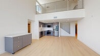 Located in Los Angeles, this contemporary two-story home offers a thoughtfully designed layout spread across two levels. Light wood flooring flows consistently throughout, complementing a clean, modern aesthetic defined by crisp white walls and abundant natural light.

The main level houses a stylish kitchen featuring sleek gray cabinetry, quartz countertops with a striking marble-veined backsplash, stainless steel appliances including a built-in dishwasher, and an undermount sink. The open living area connects seamlessly to the rest of the floor, supported by multiple hallways and well-organized closet storage.

The bathrooms are finished to a high standard, showcasing gray vanities with white quartz counters, large mirrors, light tile flooring, and glass-enclosed showers with elegant tile surrounds — one featuring floor-to-ceiling subway-style mosaic tile detailing.

The upper level is a standout, featuring soaring double-height ceilings and oversized windows that flood the space with sunlight. The primary bedroom opens directly onto a spacious private balcony offering panoramic views of the Downtown Los Angeles skyline. A generously sized walk-in closet with built-in hanging rails completes the upper level. The second bedroom also enjoys bright natural light and city views through large windows.