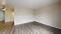 Located at 4000 58th St N in Kenneth City, Florida, this well-appointed 1-bedroom, 1-bathroom residence offers a thoughtfully designed single-floor layout. Wood-look luxury vinyl flooring runs throughout, lending a cohesive and contemporary feel to the entire space. The open-concept living and dining area is bright and airy, highlighted by a large sliding glass door that fills the room with natural light and provides direct access to a private balcony with outdoor views. The kitchen is outfitted with crisp white shaker-style cabinetry, ample upper and lower storage, light marble-look countertops, and a stainless sink — complemented by a full-size black refrigerator. A dedicated laundry nook with a stacked washer and dryer unit adds everyday convenience. The generously sized bedroom features a ceiling fan, a natural light window, and comfortable proportions, supported by three closets offering exceptional storage throughout the unit. The full bathroom includes a tub-shower combination with white tile surround, a vanity with marble-look countertop, and matching wood-look flooring. Hallways connect the spaces efficiently, completing this clean and functional floor plan.