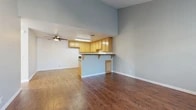 Located at 2880 W Ball Rd in Anaheim, California, this two-bedroom, one-bathroom single-floor unit offers a well-designed layout that maximizes its compact footprint. The open-concept living and kitchen area is anchored by rich, dark hardwood-style flooring and striking vaulted ceilings that lend a sense of spaciousness throughout. A ceiling fan keeps the living area comfortable, while a wide window floods the space with natural light and outdoor views.

The kitchen is thoughtfully appointed with light maple cabinetry offering ample storage, dark granite-style countertops, a stainless steel dishwasher, and a built-in range. A peninsula with overhanging countertop provides an ideal breakfast bar, seamlessly connecting the kitchen to the living area.

Both bedrooms feature soft carpeting and windows with slatted blinds that invite natural light. The primary bedroom is generously sized and includes a mirrored sliding closet door. The second bedroom also benefits from a ceiling fan and a wall-mounted HVAC unit for year-round comfort.

The full bathroom includes a warm wood-toned vanity with a white countertop, a large mirror, and a sliding-door shower/tub enclosure, all finished with hardwood-style flooring. A hallway and dedicated closet complete the practical, efficient layout of this Anaheim residence.