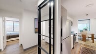 Located in Chicago's sought-after Streeterville neighborhood, this well-appointed one-bedroom, one-bathroom residence offers a thoughtful layout across a single floor. The bedroom is a standout feature, showcasing a striking curved bay window that frames outdoor views and fills the room with natural light, complemented by light wood-tone flooring and clean white walls that create a calm, restful atmosphere. The dining room is elegant and inviting, anchored by a substantial wood dining table and highlighted by an eye-catching arched mirror that adds architectural character to the space. Natural light flows in through a window overlooking an outdoor terrace area, enhancing the room's airy feel. The galley-style kitchen is efficiently designed with light wood cabinetry, white quartz countertops, a white tile backsplash, and a full suite of stainless steel appliances, providing a functional and stylish cooking environment. The bathroom features a wide, light wood vanity with a white quartz countertop, an undermount sink, and a large mirror, delivering a clean and modern aesthetic. A hallway and dedicated closet round out the layout, ensuring practical storage. Throughout the residence, light wood flooring, neutral tones, and consistent modern finishes create a cohesive and polished living environment.