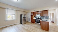 This single-floor, 2-bedroom, 1-bathroom unit offers a practical and well-organized layout across a compact but efficient footprint. The kitchen is a standout area, featuring rich warm-toned wood cabinetry, a stainless steel refrigerator and range, light tile-style flooring, and a subway tile backsplash. Ample upper and lower cabinet storage, combined with a sink and under-range ventilation hood, make this a fully functional cooking space. Natural light enters through a nearby window, brightening the open kitchen area.

Both bedrooms are carpeted and finished with neutral, warm wall tones. The primary bedroom includes a built-in closet with a sliding door and rod storage, offering convenient organization. The second bedroom is well-lit with multiple windows and features a ceiling fan, allowing for natural ventilation and light. Each bedroom provides a comfortable, quiet retreat.

The bathroom is thoughtfully finished with large white floor tiles and eye-catching slate-style stone wall tiles in earthy tones of rust, brown, and gray. A dark-cabinetry vanity with a white sink, a toilet, and a glass-door shower complete the space. A frosted window provides natural light while maintaining privacy. Throughout the unit, clean white trim and neutral walls create a cohesive, understated aesthetic.