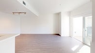 Located at 1446 Tamarind Ave in the heart of Hollywood, Los Angeles, this single-floor residence offers a clean, modern aesthetic throughout its well-appointed layout. The open-concept living area features rich, dark hardwood-style flooring and crisp white walls, creating a bright and airy atmosphere. Natural light filters in generously, enhancing the sense of space throughout the unit. The kitchen is thoughtfully designed with a two-tone cabinetry scheme — pairing dark lower cabinets with white upper cabinets — complemented by white quartz countertops, a herringbone tile backsplash, and a full suite of stainless steel appliances including a gas range, microwave, and refrigerator. A peninsula provides additional counter space and separates the kitchen from the main living area. The bedrooms are finished with plush neutral carpet and feature ample closet space, with natural light streaming through windows that offer views of the surrounding building exterior. The bathroom is finished to a high standard, showcasing a dark wood-grain vanity with white countertops, an illuminated backlit mirror, and a glass-enclosed shower. Throughout the unit, the interplay of light finishes and modern fixtures creates a cohesive and contemporary living environment.