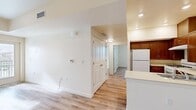Located at 1335 W Luchessa Ave in Gilroy, CA, this single-floor residence offers a clean, modern layout with consistent light wood-style flooring throughout. The open-concept kitchen is well-appointed with rich warm-toned cabinetry, light countertops, a gas range, refrigerator, and a peninsula that provides both additional prep space and a natural divide from the living area. Recessed lighting and flush-mount fixtures illuminate the space effectively throughout. The living area is bright and open, benefiting from a glass door that leads to a private patio, allowing natural light to fill the room. Bedrooms are comfortably sized with large sliding closets and windows offering outdoor views of the surrounding landscape, including mountain scenery. The bathroom features a full tub and shower combination, a vanity with wood cabinetry and a mirror, and the same wood-style flooring found throughout the unit. A hallway connects the main living spaces to the private areas, with additional closet storage accessible along the way. The overall aesthetic is clean and neutral, with crisp white walls and trim creating a bright, welcoming ambiance throughout the entire residence.