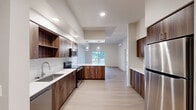 Located at 6914 NE 126th St in Vancouver, WA, this thoughtfully designed single-floor home offers 3 bedrooms, 3 bathrooms, a den, and generous living space throughout. Light wood-tone flooring flows consistently across the entire layout, creating a cohesive and clean aesthetic.

The open-concept kitchen, dining, and living area serves as the heart of the home. The kitchen is equipped with rich walnut-toned cabinetry, white quartz countertops, subway tile backsplash, stainless steel appliances including a refrigerator and range, and a peninsula with pendant lighting. A wall-mounted mini-split unit provides efficient climate control. The living area opens directly to a patio via sliding glass doors, bringing in natural light and outdoor views.

The spacious primary bedroom features a second patio access point through sliding doors, along with two windows that invite natural light. Its en-suite bathroom includes a dual-sink vanity with gray cabinetry and a large mirror. Additional bathrooms feature tub-shower combinations with brushed nickel fixtures. Closets throughout include wire shelving systems for organized storage.

The den offers a versatile flex space, while the dedicated laundry room and well-connected hallway add to the home's functional layout. Recessed lighting and a neutral color palette complete the modern, move-in-ready interior.
