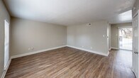 Located at 9842 Audelia Rd in Dallas, TX, this two-story, 2-bedroom, 4-bathroom home offers a clean, updated interior with a neutral color palette throughout. The main floor hosts the combined kitchen and living area, where wood-look flooring runs seamlessly underfoot. The kitchen is outfitted with crisp white cabinetry, quartz-style countertops, and black appliances including an electric range and over-the-range microwave. A galley-style layout opens toward the living room, which benefits from natural light streaming through slatted blinds. The living area is spacious and open, with a ceiling fan adding functional comfort. The bathrooms feature white vanities with modern hardware, large mirrors, and contemporary light fixtures, maintaining a consistent, refreshed aesthetic. Upstairs, both bedrooms are finished with plush carpeting and neutral walls, creating a calm retreat. The primary bedroom is generously sized with a dedicated closet, while windows framing views of mature trees provide a pleasant natural backdrop. Each bedroom connects to its own bathroom, enhancing privacy. Two closets and two staircases add to the home's practical layout. Overall, the space presents a well-maintained, move-in-ready environment with cohesive modern finishes throughout.
