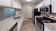 Located at 9991 Arbor Montgomery Ln in Cincinnati, OH 45249, this single-floor unit offers a well-designed layout with clean, contemporary finishes throughout. The kitchen is a standout feature, equipped with crisp white cabinetry, granite countertops, a tile backsplash, stainless steel appliances including a built-in microwave, and wood-look flooring that adds warmth and durability. A peninsula counter connects the kitchen to the dining and living areas, creating an open, cohesive flow. The living and dining spaces are finished with neutral gray walls and plush carpeting, complemented by a ceiling fan and a pendant light fixture. Natural light filters in through blinds-fitted windows, and the entryway features a classic paneled door with a hardwood-style tile entry mat. The bedrooms are generously sized with soft carpeting, gray walls, and windows that bring in natural light. One bedroom includes a louvered bifold closet door for ample storage. The bathroom is well-appointed with white cabinetry, granite countertops, a framed mirror, and wood-look plank flooring, with convenient access to the adjacent bedroom. Overall, the unit presents a polished, move-in-ready aesthetic with consistent finishes across all spaces.