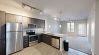 Located at 111 Dupont Circle in Phoenix, AZ, this 2-bedroom, 1-bathroom residence offers a thoughtfully designed single-floor layout. The open-concept kitchen and living area forms the heart of the home, where dark espresso cabinetry, granite countertops, and a full suite of stainless steel appliances — including a refrigerator, range, microwave, and dishwasher — create a sleek, modern aesthetic. A peninsula with pendant lighting provides additional counter space and serves as a natural divide between the kitchen and the adjoining living area. Track lighting and light wood-style flooring complete the kitchen's contemporary look. The living area features plush carpeting, a ceiling fan, and a window that brings in natural light and outdoor views of the surrounding landscape. Two carpeted bedrooms offer comfortable retreats with neutral tones and ample wall space. The primary bedroom is generously proportioned and includes a ceiling fan and a window with exterior views. The shared full bathroom is finished with a dark-cabinet vanity, granite countertop, a large mirror, modern light fixtures, and a combination tub and shower. A connecting hallway ties the layout together efficiently, contributing to the home's functional and cohesive flow.