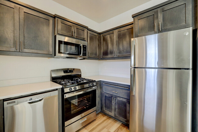 Kitchen with gas range and microhood - Enclave Apartments