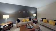 Located at 101 Mariners Cir in Sheffield Lake, Ohio, this single-floor home offers a well-organized layout with a range of functional and comfortable living spaces. The living room serves as a central gathering area, distinguished by a bold dark accent wall that contrasts with neutral carpeting. The space accommodates both a seating area and a media setup, with a sliding glass door providing natural light and direct access to an outdoor patio furnished for relaxing or entertaining.

The kitchen features warm oak cabinetry, light countertops, and includes a gas range with an over-the-range microwave, offering practical functionality for everyday cooking. A dedicated laundry room houses a full-size washer and dryer with built-in shelving for storage convenience.

The home includes multiple bedrooms, each finished with plush carpeting, ceiling fans, and natural light from windows with curtains or blinds. One bedroom features a bold navy accent wall with a closet, while another offers direct access to a bathroom, functioning as a primary suite. Each room maintains a cohesive, neutral palette with warm wood furniture accents.

Two full bathrooms serve the home, one featuring a tub-shower combination with tile flooring and oak vanity, and another with a walk-in shower and matching finishes, completing this practical and inviting residence.