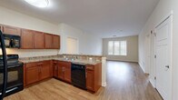Located at 1 Overlook Dr in Monroe Township, NJ, this well-appointed two-bedroom, two-bathroom residence offers a thoughtfully designed single-floor layout. The open-concept kitchen and living area serves as the heart of the home, featuring warm cherry wood cabinetry, granite-style countertops, a peninsula with bar seating, and black appliances including a dishwasher and refrigerator. Light wood-look flooring runs throughout the main living areas, complemented by neutral-toned walls that create a bright, welcoming atmosphere. Natural light filters in through multiple windows fitted with blinds. The primary bedroom is generously proportioned, offering ample space and direct access to a walk-in closet with wire shelving systems. The second bedroom also features wood-look flooring and a large window. Both bathrooms are finished with tile flooring, cherry wood vanities, and mirrors. One bathroom includes a spacious walk-in shower with grab bars, while the other features a combination tub and shower. A dedicated in-unit laundry area with a stacked washer and dryer adds everyday convenience. Three closets provide abundant storage throughout the residence, along with a utility room rounding out the functional layout.