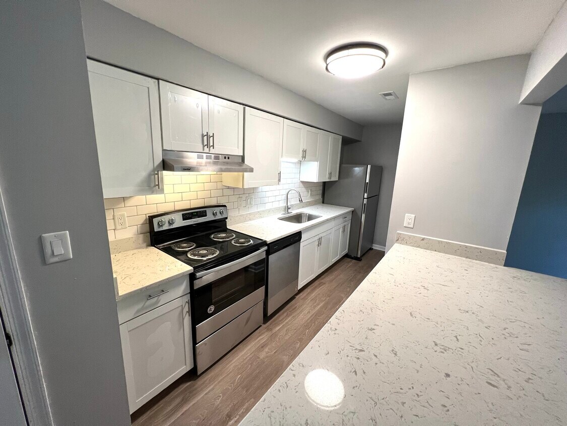 Bright white kitchen with stainless steel appliances, shaker cabinets and quartz countertops - 2030 Quaker Landing
