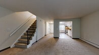 Located at 145 Harbor Pond Dr in Meriden, CT, this multi-floor home spans three levels and offers a well-organized layout with 2 bedrooms, 3 bathrooms, and generous living space throughout. The main level features a carpeted living room with natural light streaming through a front-facing window and an iron-railed staircase that adds a classic architectural touch. Adjacent to the living area, the kitchen is outfitted with crisp white cabinetry, granite-style countertops, stainless steel appliances including a refrigerator, range, and dishwasher, and light wood-tone flooring that gives the space a clean, modern feel. The upper floors house two well-sized bedrooms, each carpeted and brightened by windows with outdoor views. The primary bedroom offers generous square footage, while a second bedroom features a distinctive vaulted, angled ceiling that adds character. Baseboard heating is present throughout, ensuring efficient climate control. Three full bathrooms serve the home, including one with a soaking tub. The basement level provides considerable unfinished utility space, housing the mechanical systems including the electrical panel and copper plumbing infrastructure, and offers potential for additional storage or future finishing. Four closets and multiple hallways contribute to the home's functional and practical layout.