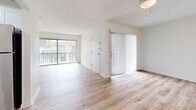 Located at 305 Glades Circle in Largo, Florida, this two-bedroom, single-floor residence offers a well-organized and functional layout. The living area is bright and open, featuring light wood-style flooring that extends throughout the main living spaces. Large sliding glass doors dressed with vertical blinds invite abundant natural light and provide access to an outdoor area with views of tropical foliage, capturing the essence of Florida living. A ceiling fan adds to the comfort of the space.

The kitchen is designed for efficiency, featuring a galley-style layout with crisp white cabinetry, a stainless steel sink, light wood-style flooring, and stainless steel appliances including a refrigerator and dishwasher — offering a clean, modern aesthetic.

Both bedrooms are carpeted for comfort and warmth. The primary bedroom is a well-proportioned retreat with large windows allowing natural light to filter in. The second bedroom also features carpet and a window with blinds. Both bedrooms are equipped with full-wall louvered closets, providing generous storage space.

Throughout the residence, neutral wall tones and textured ceilings maintain a consistent, clean aesthetic, making this Largo home a practical and inviting space.