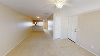 This single-floor residence offers a comfortable and functional layout designed for everyday living. The open-concept living area greets you at the entry, featuring neutral-toned carpet, a ceiling fan with light fixture, and a tiled entryway. The space flows naturally toward the kitchen, which is equipped with light oak cabinetry, speckled countertops, black appliances including an electric range, microwave, and dishwasher, and a skylight-style ceiling panel that brightens the room.

The two bedrooms are finished with plush carpet and ceiling fans, providing a cozy and restful atmosphere. One bedroom features mirrored sliding closet doors with a black frame, while the other also includes a mirrored wardrobe and windows that invite natural light. The full bathroom is clean and simply appointed, featuring a tub-shower combo with white surrounds, a speckled countertop vanity, and well-lit mirror.

A standout feature of this residence is the private balcony, accessible via dual sliding glass doors. The balcony offers an elevated outdoor view of the surrounding area, including swaying palm trees, a sparkling community pool, and lush landscaping below — a pleasant retreat that adds significant charm to this well-rounded home.