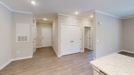 Located at 6725 N Main St in Columbia, SC, this well-designed single-floor residence offers 2 bedrooms and 3 bathrooms in a thoughtfully laid-out floor plan. The interior presents a cohesive, neutral color palette with warm beige tones and crisp white trim throughout, creating a clean and inviting atmosphere.

The kitchen is a functional highlight, featuring white shaker-style cabinetry with ample storage, quartz countertops, a peninsula with a built-in sink, and a full suite of stainless steel appliances including a refrigerator, range, microwave, and dishwasher. Light wood-look flooring ties the kitchen and entryway together seamlessly.

The primary bedroom is generously sized, with multiple windows allowing natural light and outdoor views, complemented by a ceiling fan and plush wall-to-wall carpet. Additional bedrooms include double-door closets and carpet flooring. The bathrooms are consistently finished with gray vanities, quartz countertops, tub-shower combinations, and light wood-look tile flooring. A dedicated laundry area adds everyday convenience.

The entryway features recessed lighting, crown molding, and hardwood-style flooring, setting a polished tone upon entry. Overall, the space reflects modern, move-in-ready finishes ideal for comfortable living.
