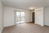 This single-floor residential unit offers a thoughtfully laid-out interior with a functional and comfortable design throughout. The kitchen is a standout feature, equipped with warm honey-toned cabinetry, granite-look countertops, a full suite of white appliances including a refrigerator, electric range, built-in microwave, and dishwasher, all set atop durable hardwood-style flooring that adds warmth to the space. An open passage connects the kitchen to the dining and living areas, which are finished with plush, neutral-toned carpeting and painted in soft, light tones that enhance the sense of openness. The living area benefits from a sliding glass door that opens to a private balcony, allowing natural light to fill the room and offering pleasant outdoor views. The bedrooms are generously proportioned, each featuring wall-to-wall carpet, sliding closet doors, and windows that bring in additional natural light. The bathroom is clean and efficiently designed, featuring a full-size soaking tub with shower combination, chrome fixtures, and hardwood-style flooring. Throughout the unit, the neutral color palette, consistent finishes, and well-maintained condition create a bright, move-in-ready atmosphere suitable for a range of lifestyles.