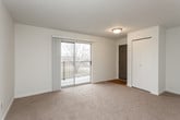This single-floor residential unit offers a thoughtfully laid-out interior with a functional and comfortable design throughout. The kitchen is a standout feature, equipped with warm honey-toned cabinetry, granite-look countertops, a full suite of white appliances including a refrigerator, electric range, built-in microwave, and dishwasher, all set atop durable hardwood-style flooring that adds warmth to the space. An open passage connects the kitchen to the dining and living areas, which are finished with plush, neutral-toned carpeting and painted in soft, light tones that enhance the sense of openness. The living area benefits from a sliding glass door that opens to a private balcony, allowing natural light to fill the room and offering pleasant outdoor views. The bedrooms are generously proportioned, each featuring wall-to-wall carpet, sliding closet doors, and windows that bring in additional natural light. The bathroom is clean and efficiently designed, featuring a full-size soaking tub with shower combination, chrome fixtures, and hardwood-style flooring. Throughout the unit, the neutral color palette, consistent finishes, and well-maintained condition create a bright, move-in-ready atmosphere suitable for a range of lifestyles.