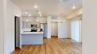 Located at 410 Pond Lily Dr in Bozeman, MT, this two-story home offers five bedrooms, three bathrooms, and a thoughtfully designed layout spread across two floors. The main level features an open-concept kitchen and living area bathed in natural light, with warm hardwood-style flooring throughout. The kitchen is well-appointed with gray shaker-style cabinetry, white quartz countertops, a stainless steel refrigerator, gas range, microwave, and dishwasher, along with a central island with pendant lighting. The living room is generously sized, featuring vaulted ceilings, a ceiling fan, recessed lighting, and large windows with roller shades that invite natural light. A staircase leads to the upper level, where the spacious primary bedroom features vaulted ceilings, plush carpeting, and a bright window. Additional bedrooms are well-proportioned and share access to clean, modern bathrooms finished with gray tile flooring, white vanities, and brushed nickel fixtures. A dedicated laundry room with a full-size washer and dryer adds everyday convenience. The attached garage provides secure parking and extra storage. This home combines modern finishes with a functional layout in a desirable Bozeman location.