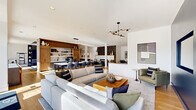 Located at 1440 Yellow Desert Way in Wendell, NC, this expansive single-floor amenity space offers a thoughtfully designed layout across a generous footprint. The open-concept main living area is anchored by plush sectional seating, a warm wood coffee table, and a sleek modern chandelier, flowing seamlessly into a dining area and a kitchen outfitted with warm wood cabinetry, open shelving, a white quartz countertop, a matte black faucet, and built-in appliances. A second living room features bold navy accent walls, light hardwood flooring, a wall-mounted TV, and direct access to the outdoors through glass-paned doors, filling the space with natural light. The dedicated exercise studio offers a clean, open layout with textured accent walls, full-length mirrors, stationary bikes, and yoga equipment beneath a ceiling fan. Adjacent to it, the expansive fitness center is equipped with a multi-functional rig system, free weights, benches, and floor-to-ceiling mirrors set over a durable checkered carpet. A games room with a pool table, tray ceiling, and custom cabinetry adds a social dimension to the space. The clean, bright hallway connects each area seamlessly and features a built-in dual water fountain station.
